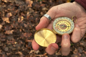 Man with compass and map in the forest. - StayWild Outdoor