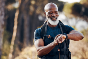 Man looking on his watch while hiking trough nature. - StayWild Outdoor